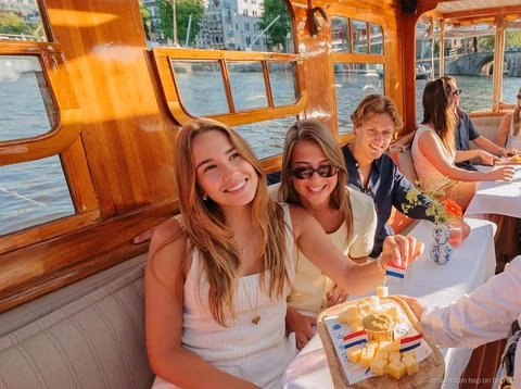 Restored saloon boat cruising an Amsterdam canal