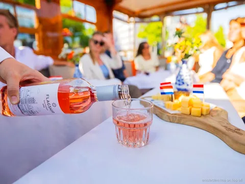 Local skipper guiding an Amsterdam canal cruise past historic houses