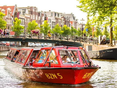 Bateau hop-on hop-off d'Amsterdam naviguant sur la ceinture de canaux classée UNESCO