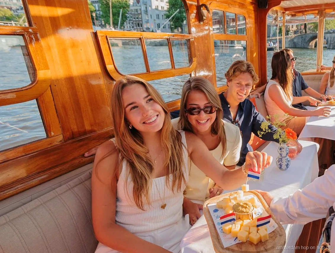 Gerestaureerde salonboot vaart door een Amsterdamse gracht
