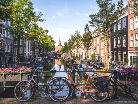 Gids leidt een Amsterdam wandeltour langs grachtenpanden