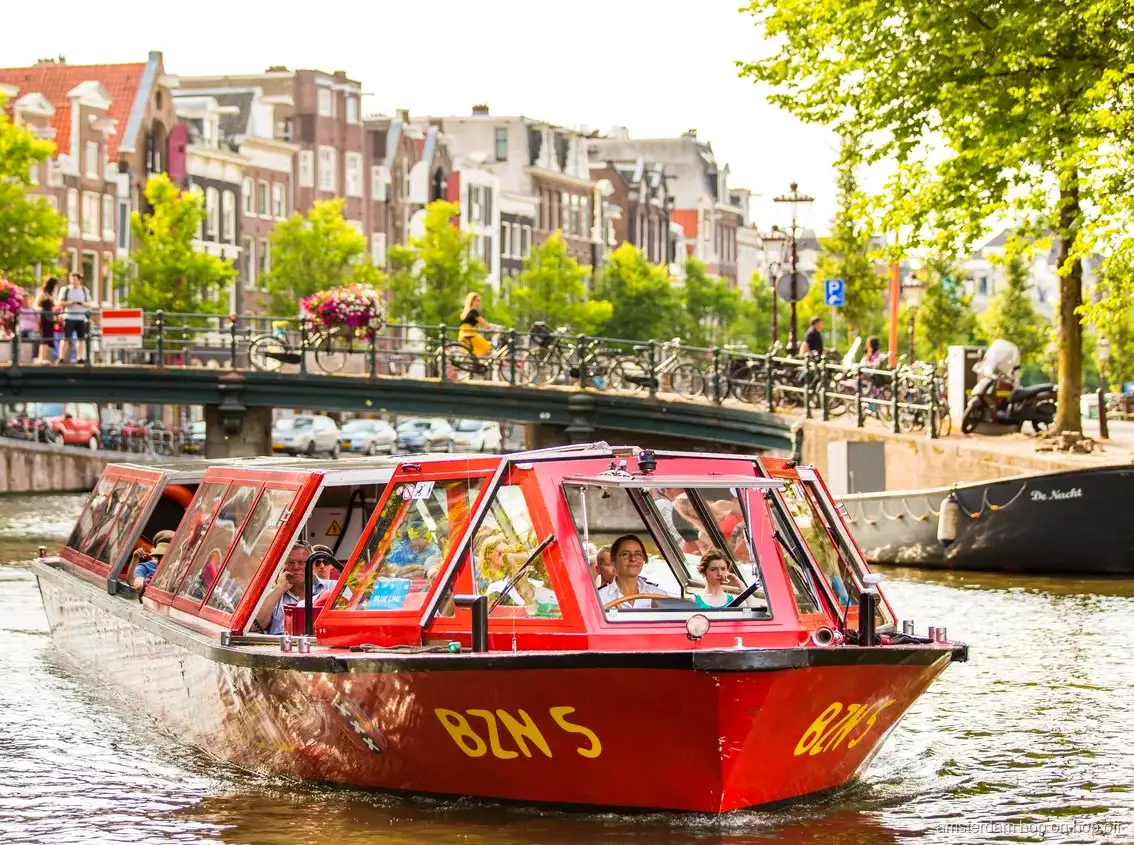 Barco turístico hop-on hop-off de Amsterdam navegando por el anillo de canales Patrimonio de la Humanidad