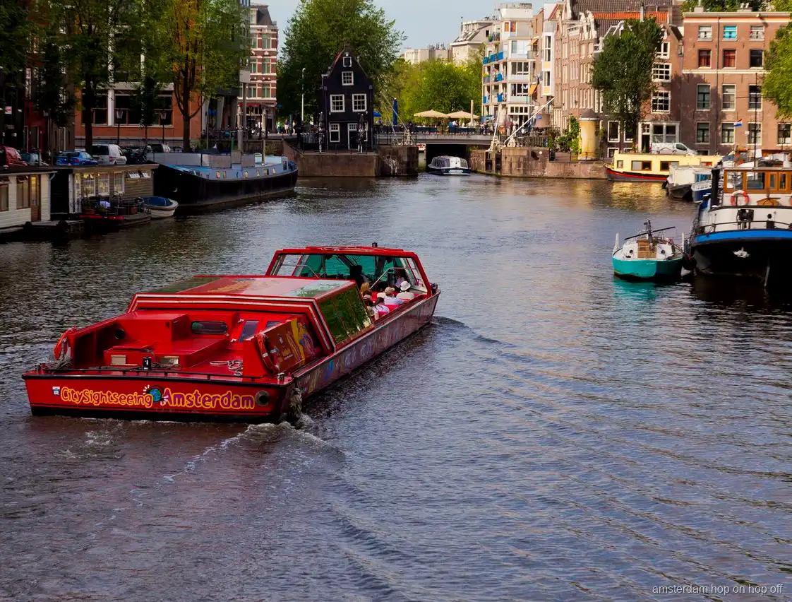 Pasajeros subiendo al bus turístico con barco hop-on hop-off de Amsterdam