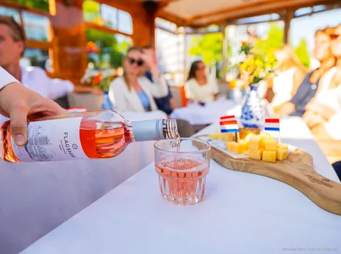 Capitaine local guidant une croisière sur les canaux d'Amsterdam devant des maisons historiques