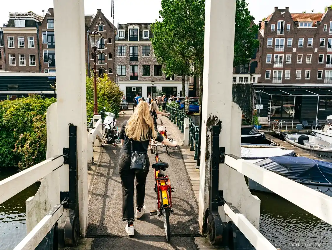 Groupe à vélo guidé traversant la ceinture de canaux d'Amsterdam