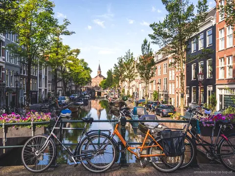 Guide menant une visite à pied d'Amsterdam devant des maisons de canal