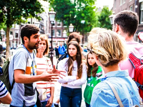 Groupe en visite guidée à pied dans le centre historique d'Amsterdam