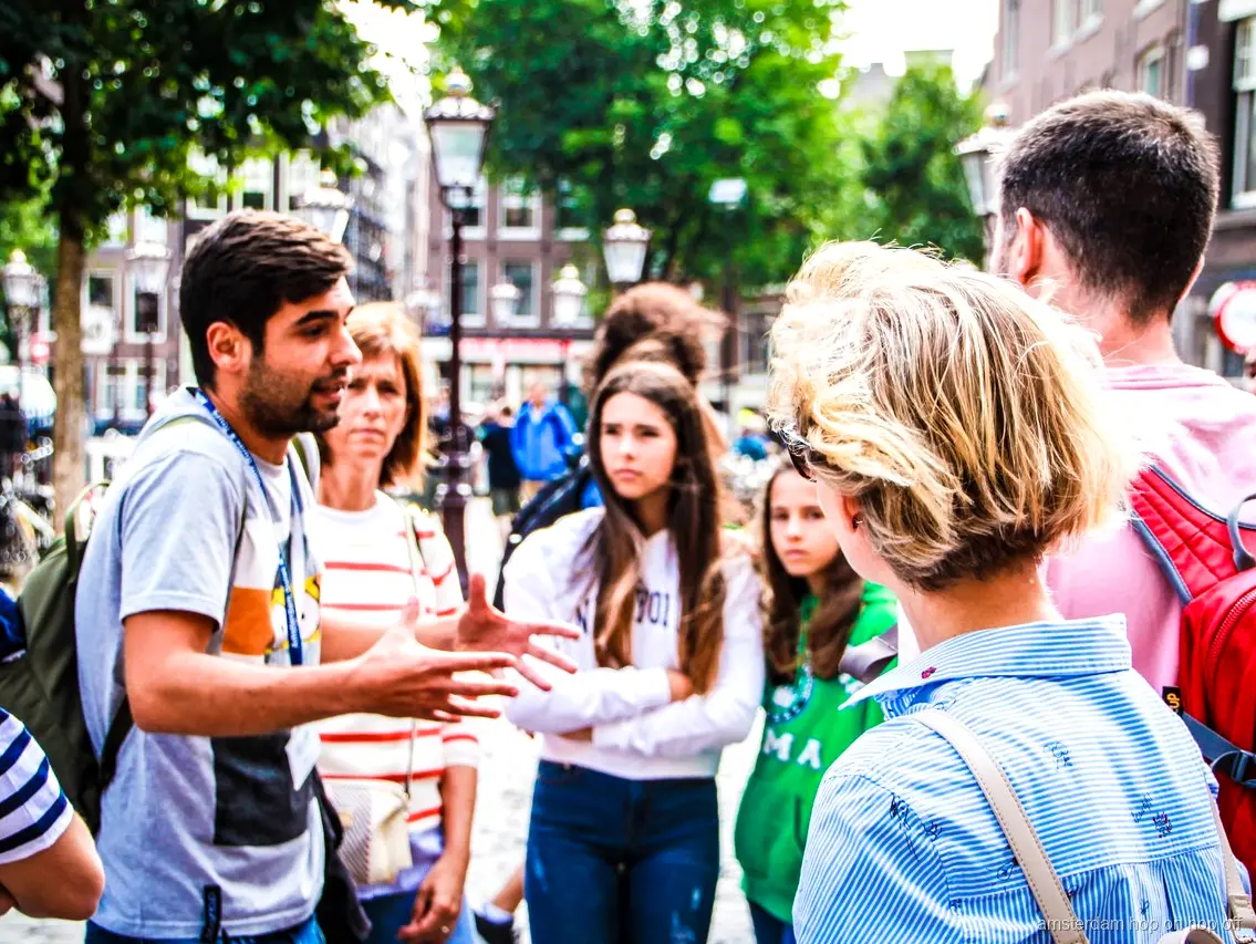 Groupe en visite guidée à pied dans le centre historique d'Amsterdam